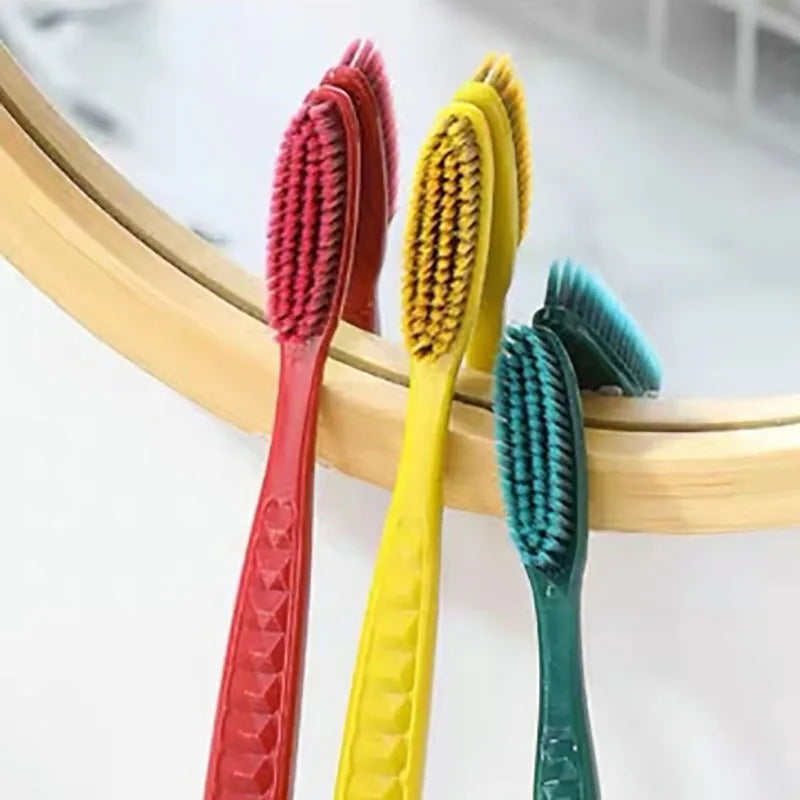 Un set de cinq brosses à dents à poils souples pour couple, de couleur rouge, jaune et vert, présentées sur une surface en bo