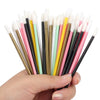 A hand holds a bundle of disposable lip brushes with nylon applicators in various colors like pink, yellow, and black.