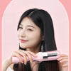 A woman is using a pink automatic hair end trimmer to style her long, dark hair.