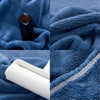 A close-up of a dark blue towel with a white U-shaped pillow cover rolled up on the edge.