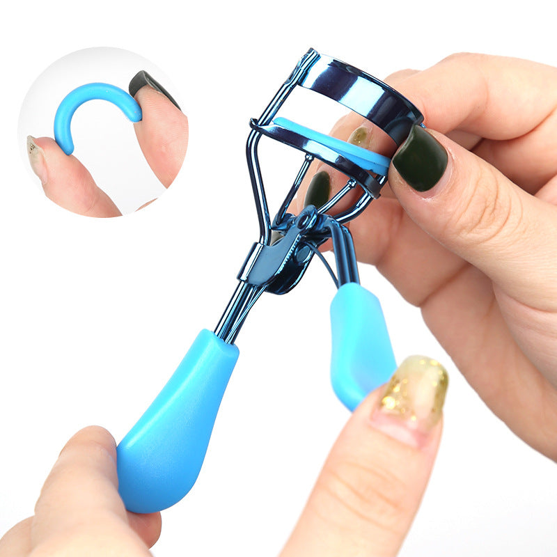 A hand holds a professional eyelash curler set, showing the curler and a guide tool.