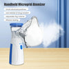 Dispositivo atomizador de microred eléctrica blanco y azul junto a una nube de niebla sobre una superficie de madera.