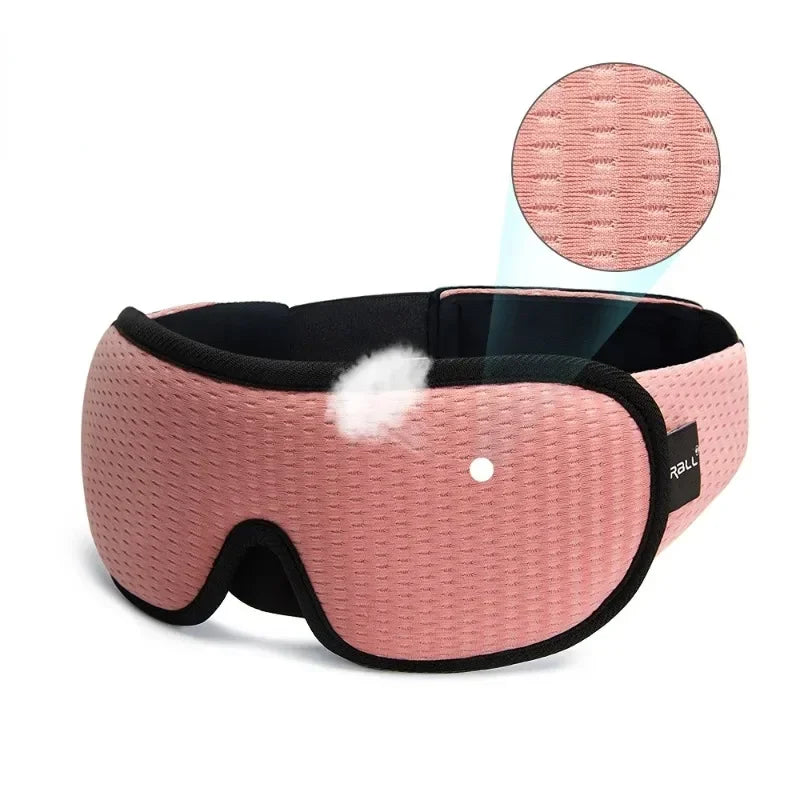 A pink 3D sleeping eye mask with a black trim and a circular insert is shown.
