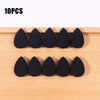 Ten black makeup sponge puffs arranged in two rows on a wooden surface.