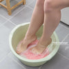 Füße in grüner Schrubbcreme zum Fußmassage und Peeling baden.