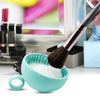 A silicone makeup brush cleaner is shown with a brush dipped in white cleaning solution, next to other makeup tools.