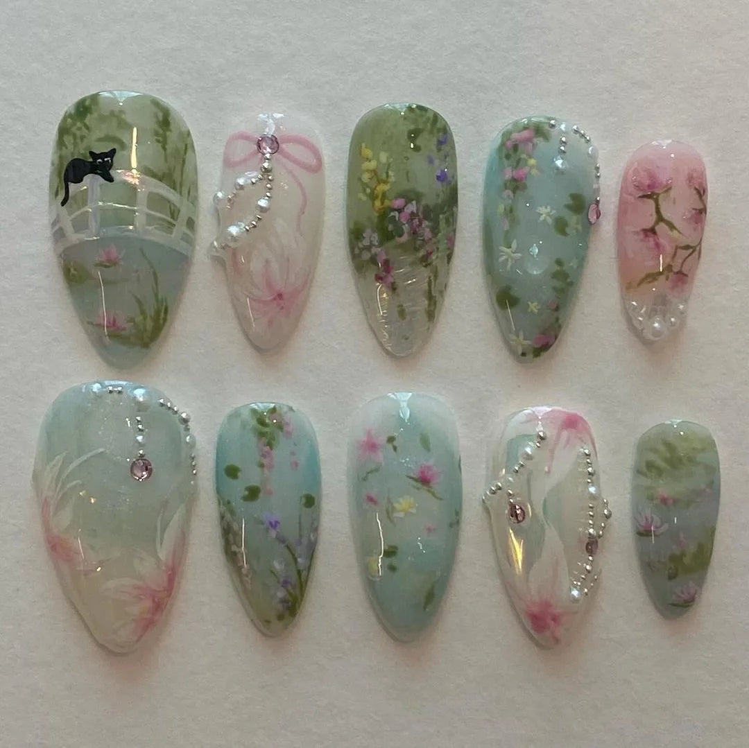 A collection of 24 press-on fake nails featuring pink and green floral designs with pearl accents.