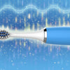 A blue electric toothbrush with a replacement head is shown against a bright, sparkling background.