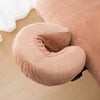 A beige reusable U-shape pillow cover used for massage or beauty treatments.
