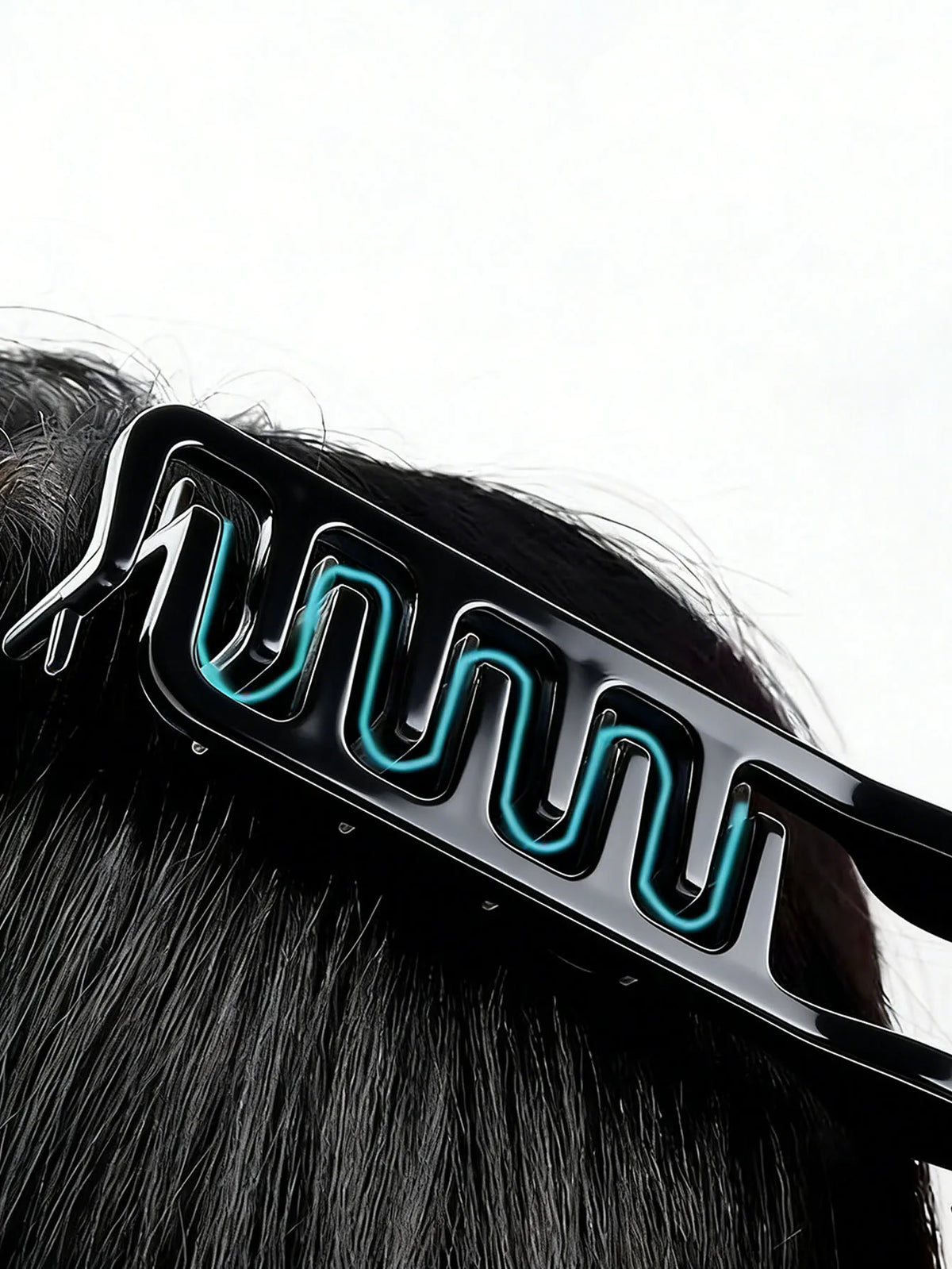 A black hair comb with blue light accents is shown being used on dark hair.