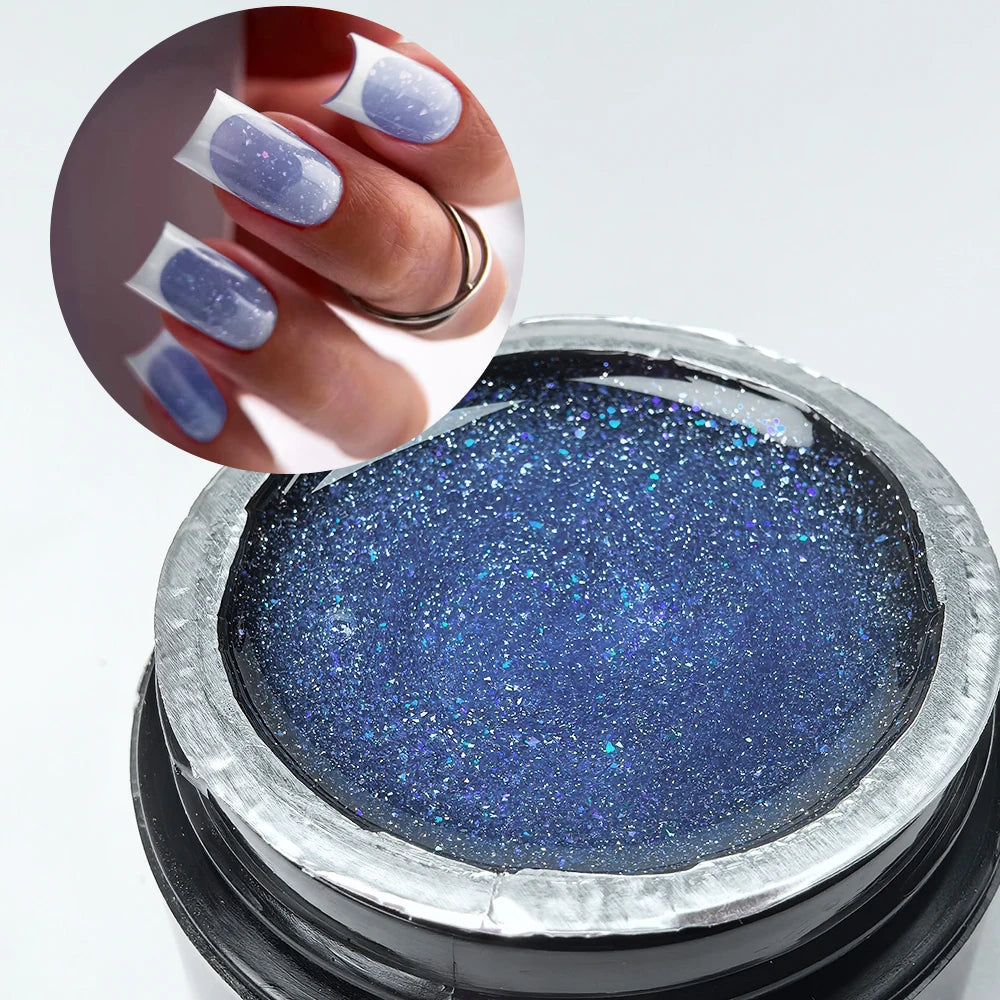 Une main avec du vernis à ongles pailleté violet tient un pot de gel constructeur bleu profond pour extensions d'ongles.