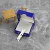 A blue box containing stainless steel single-sided shaving razor blades and a wooden stand.