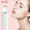 A woman is using a white facial beauty device for cleansing and lifting.