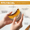 Hands hold a gold and brown facial brush demonstrating its use for lifting, tightening, and improving blood circulation.