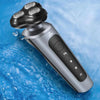 A silver electric shaver and trimmer device is shown submerged in blue water.
