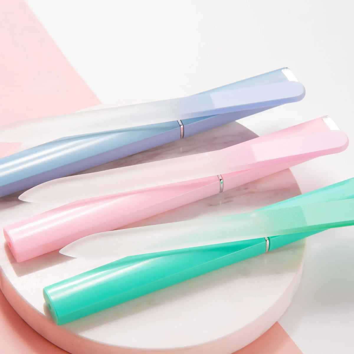 A set of double-sided etched glass nail files in various pastel shades, including blue, pink, and mint green.