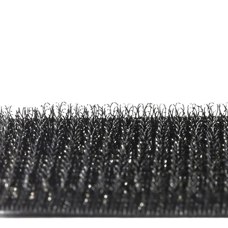 Gros plan d'un ensemble de pinces et d'un outil de coiffage noir à double manche avec des poils fins et texturés.