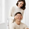 A woman is using a smart ultrasonic tooth cleaner on a man's face, demonstrating the product.