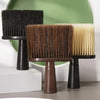 Three hair duster brushes with black, brown, and blonde bristles displayed on a stand.