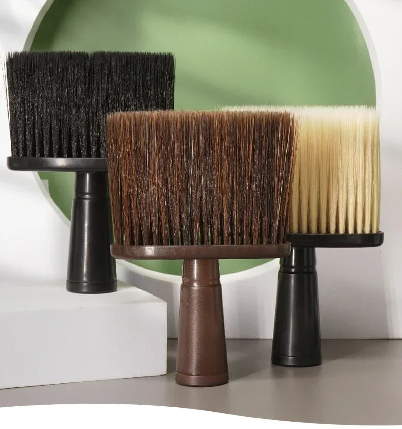 Three hair duster brushes with black, brown, and blonde bristles displayed on a stand.