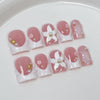 Un set de uñas postizas de perla rosa nude y flor, exhibidas en un plato blanco.