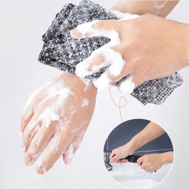 A hand is using an exfoliating back scrubber bath towel to cleanse the skin.