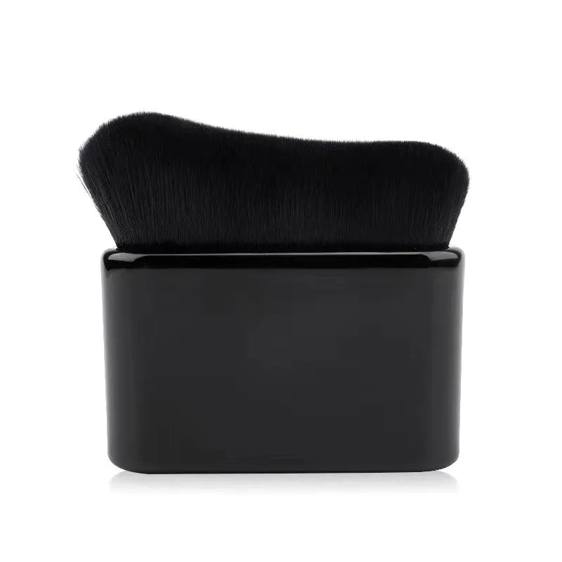 A black makeup brush with a dense, tapered tip is shown against a white background.