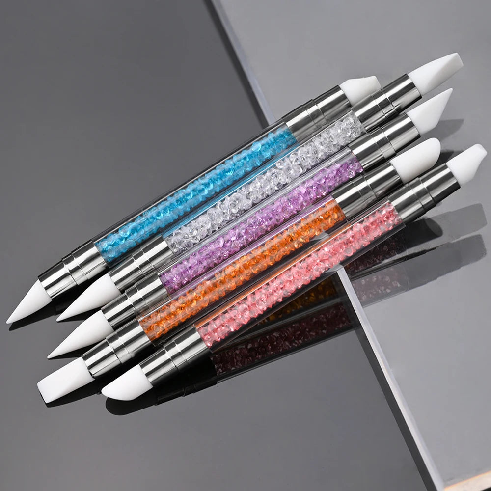 A set of pink nail art liner brush pens with ultra-fine tips arranged diagonally on a gray surface.