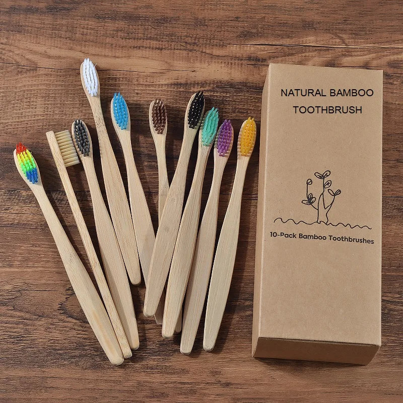 Une boîte de 10 brosses à dents en bambou naturelles posées sur une surface en bois.
