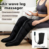 Eine Frau benutzt einen schwarzen Airwave Beinmassierer an ihren Beinen in einem Wohnzimmer.