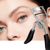A close-up of a silver eyelash curler tool being used on a woman's eye.