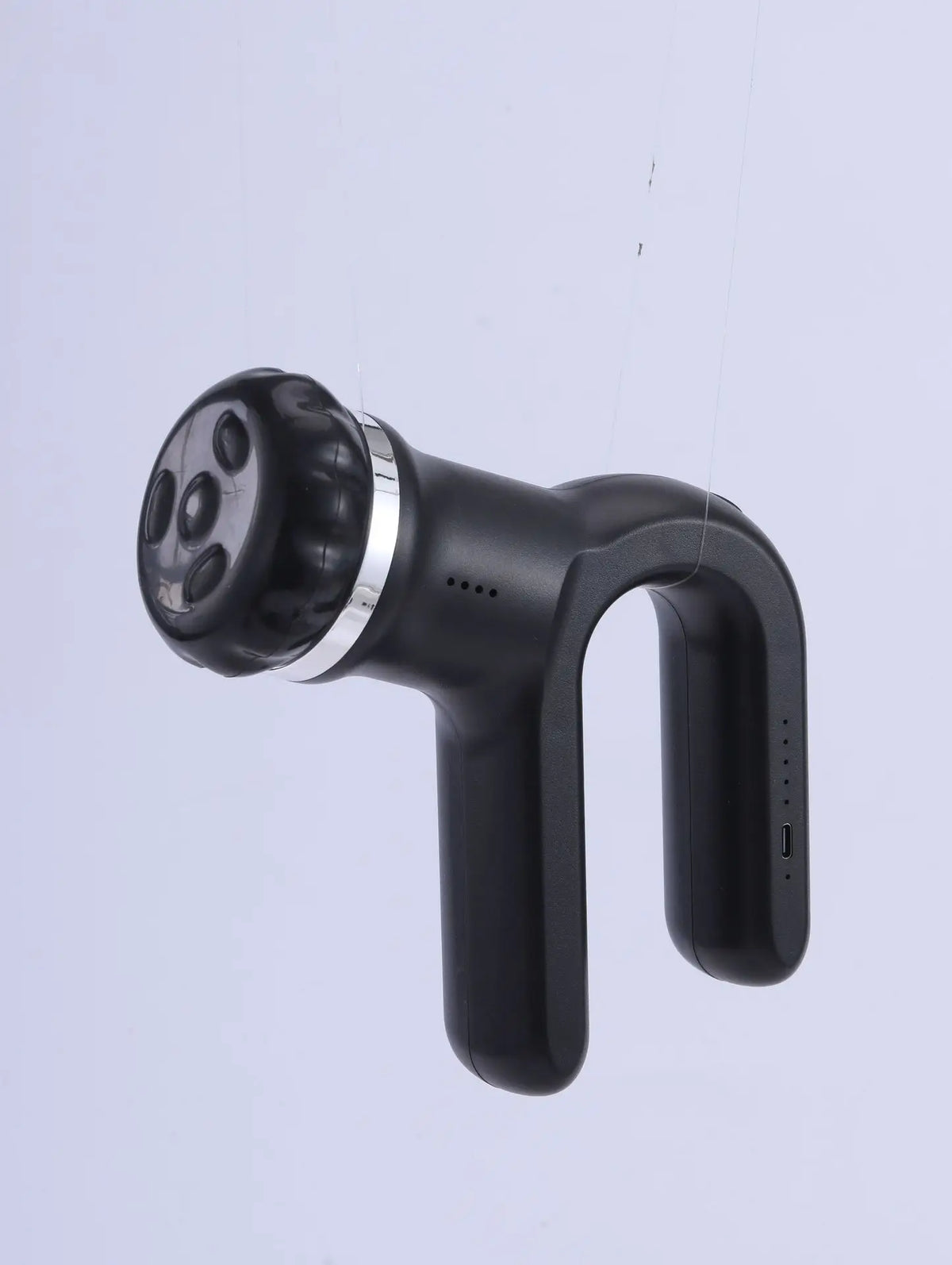 Schwarze 4-in-1 kabellose Massagepistole mit strukturiertem Kopf und Griff vor hellem grauem Hintergrund.