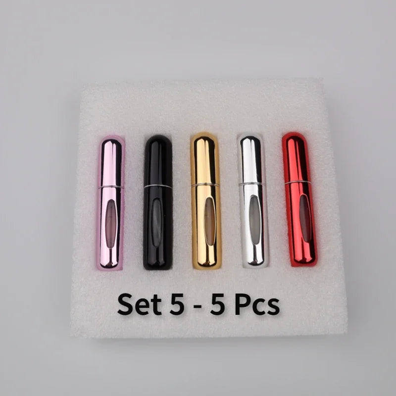 A set of five colorful 5ml travel perfume atomizer bottles arranged on a white surface.