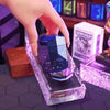 A hand is holding a purple portable magnetic electric shaver for men on a dark surface.