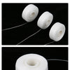 Three white spools of dental floss are displayed against a black background.