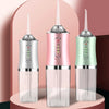 A set of three USB rechargeable dental flossers in silver, pink, and mint green are displayed on a light pink background.