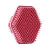 A pink silicone facial cleaning brush with numerous short bristles for deep scrubbing.
