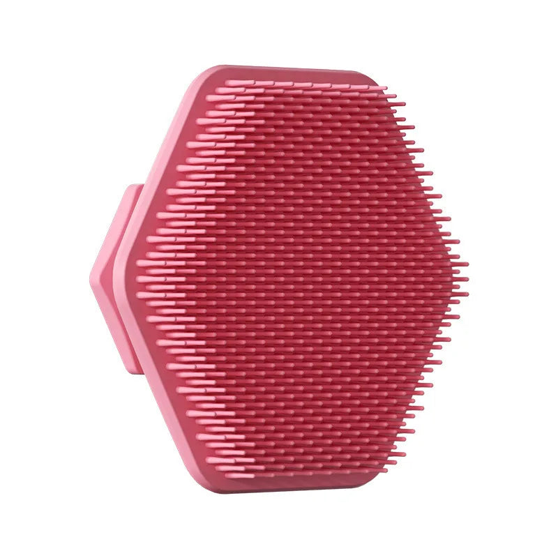 A pink silicone facial cleaning brush with numerous short bristles for deep scrubbing.
