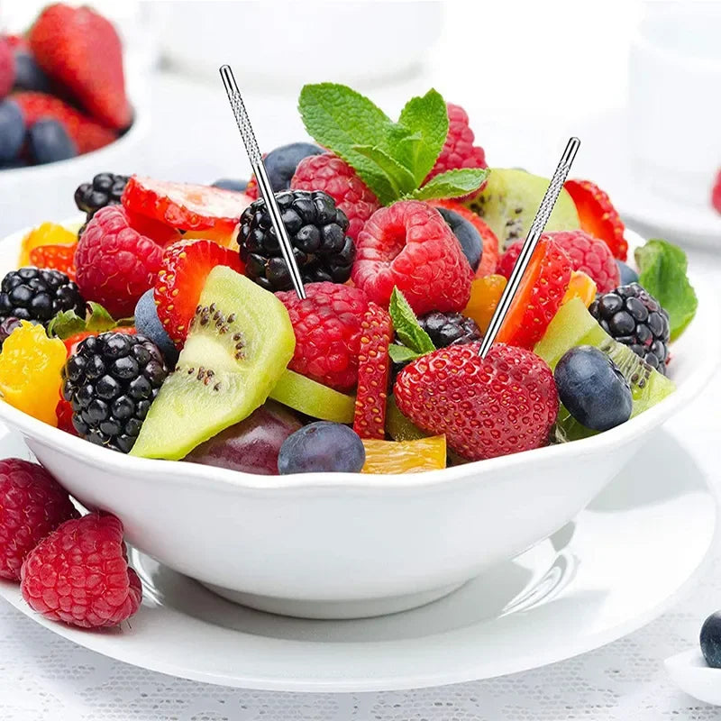 Un bol de fruits frais comme des fraises, framboises, bleuets, kiwi et segments d'agrumes, garni de feuilles de menthe