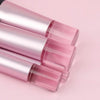 A set of ten pink and iridescent makeup brushes arranged diagonally on a light pink background.