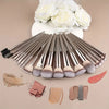 A complete makeup brush set featuring various brushes, powder, and blush in shades of nude and pink on a beige background.