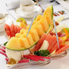 A platter of fresh fruit slices like watermelon, mango, and apple arranged with stainless steel toothpicks.