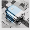 A light blue and silver mini electric beard trimmer shaver resting on a geometric gray surface.