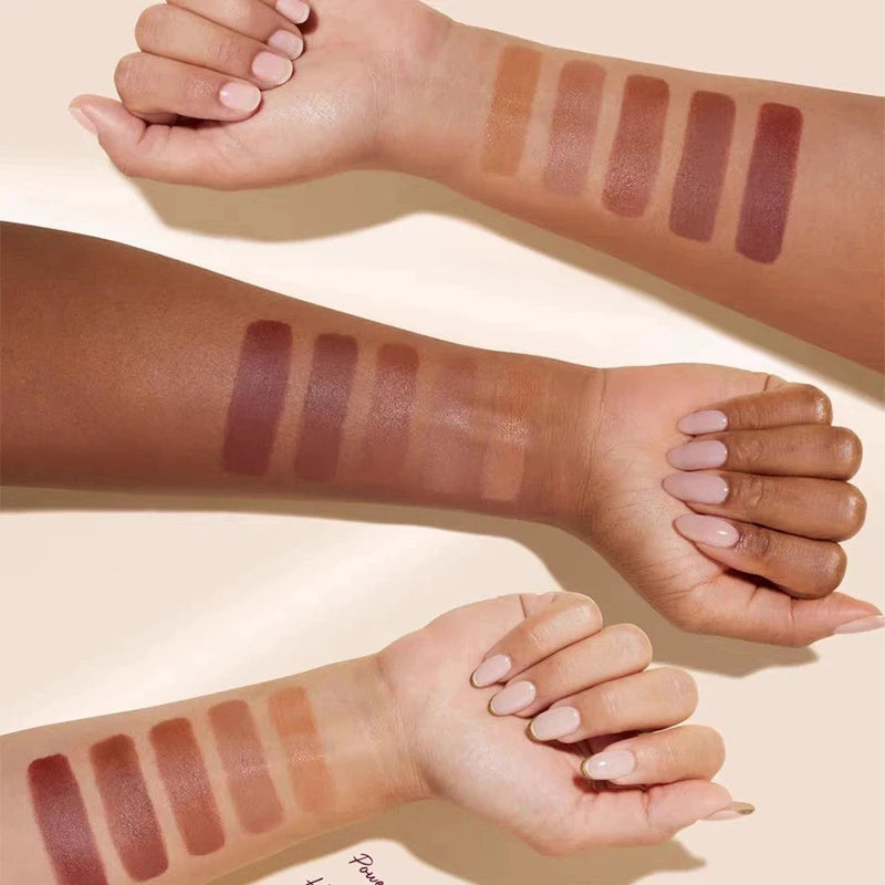 A hand is shown applying liquid bronzer contour foundation sticks in various shades onto the arm.