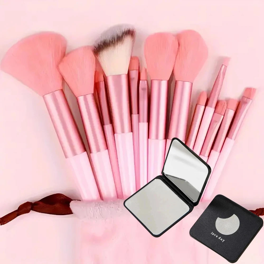 A collection of pink makeup brushes and a compact mirror are displayed on a pink background.