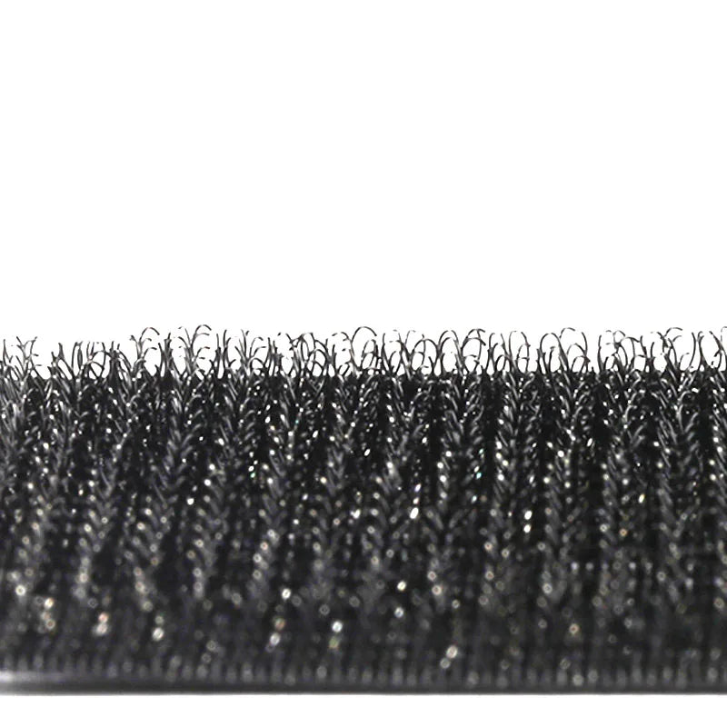 Gros plan d'un ensemble de pinces et d'un outil de coiffage noir à double manche avec des poils fins et texturés.