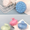 A collection of silicone scalp massage and body brushes in various shades of green, pink, and blue.