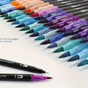 A row of 12 dual-tip art markers in various vibrant colors is displayed diagonally on a white surface.