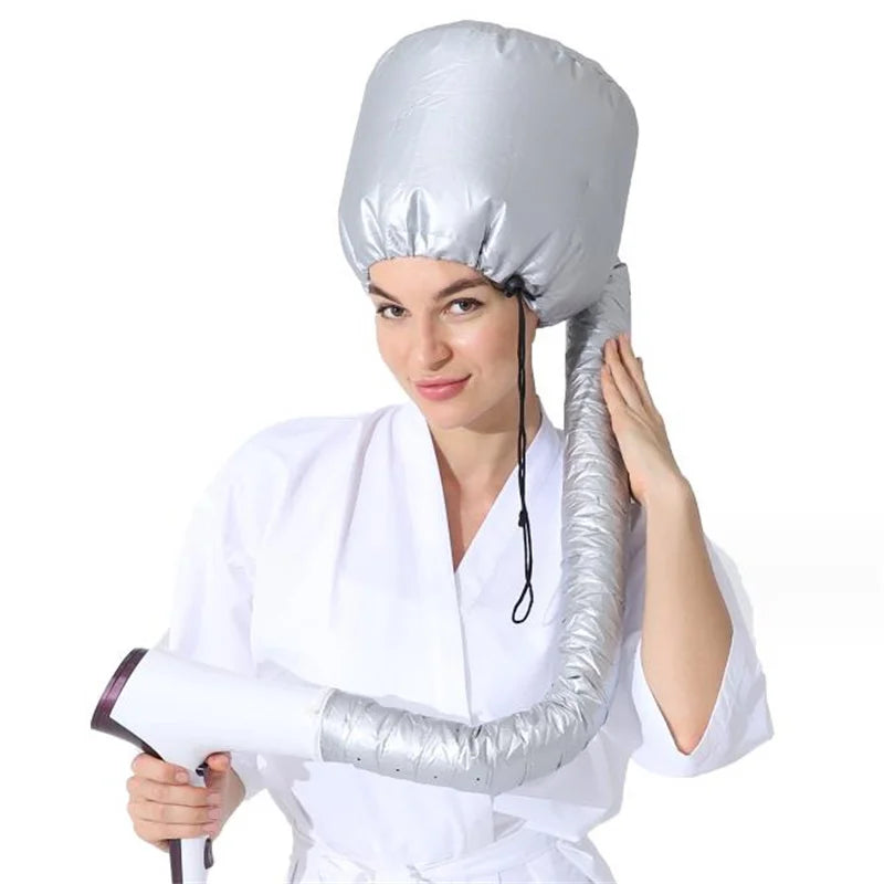 A woman wearing a silver adjustable hair drying cap while using a handheld dryer.