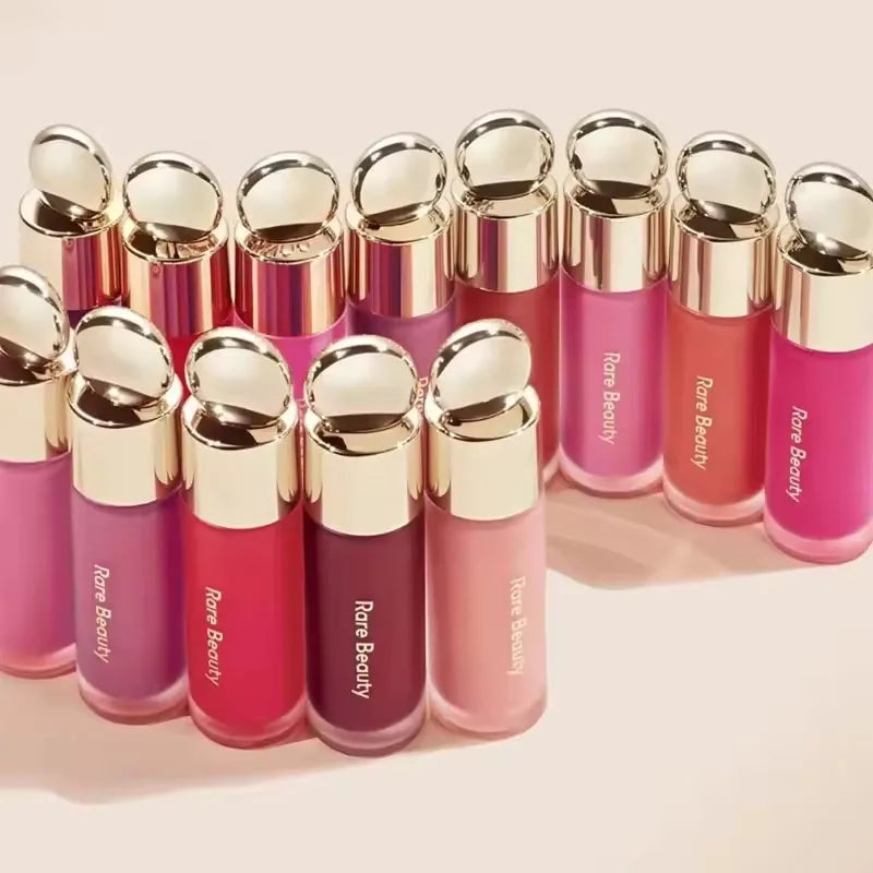 A collection of liquid bronzer contour foundation sticks in various shades of pink and coral.